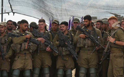 Des soldats israéliens écoutant le ministre de la Défense, Yoav Gallant, lors de sa visite d'une zone de transit près de la frontière avec la bande de Gaza, dans le sud d'Israël, le 19 octobre 2023. (Crédit : Tsafrir Abayov/AP Photo)