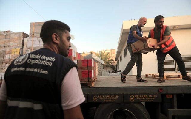 Des Palestiniens déchargeant des boîtes de médicaments d'un camion arrivé au complexe médical Nasser, dans le cadre du lot d'aide humanitaire entrée dans la bande de Gaza depuis le point de passage de Rafah le 22 octobre 2023, dans la ville de Khan Younis, au sud de Gaza, le 23 octobre 2023. (Crédit : Mohammed Dahman/AP Photo) Des Palestiniens déchargeant des boîtes de médicaments d'un camion arrivé au complexe médical Nasser, dans le cadre du lot d'aide humanitaire entrée dans la bande de Gaza depuis le point de passage de Rafah le 22 octobre 2023, dans la ville de Khan Younis, au sud de Gaza, le 23 octobre 2023. (Crédit : Mohammed Dahman/AP Photo)