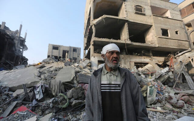 Un Palestinien devant un immeuble détruit par une frappe israélienne à Gaza, le 25 octobre 2023. (Crédit : Hatem Ali/AP Photo)