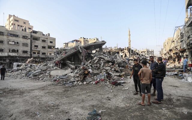 Des Palestiniens inspectent les dommages causés aux bâtiments détruits par les frappes aériennes israéliennes à Gaza City, le 28 octobre 2023. (Crédit : AP Photo/Abed Khaled)