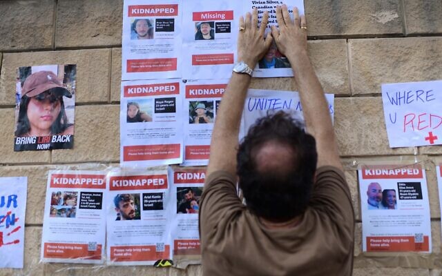 Des familles accrochent des affiches montrant les personnes prises en otage par les terroristes de Gaza, aux abords du ministère de la Défense à Tel Aviv, le 14 octobre 2023. (Crédit : Tomer Neuberg/FLASH90) Des familles accrochent des affiches montrant les personnes prises en otage par les terroristes de Gaza, aux abords du ministère de la Défense à Tel Aviv, le 14 octobre 2023. (Crédit : Tomer Neuberg/FLASH90)