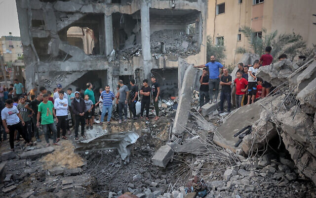 Des Palestiniens sur les lieux d'une frappe aérienne israélienne dans la bande de Gaza, le 17 octobre 2023. (Crédit : Atia Mohammed/Flash90)