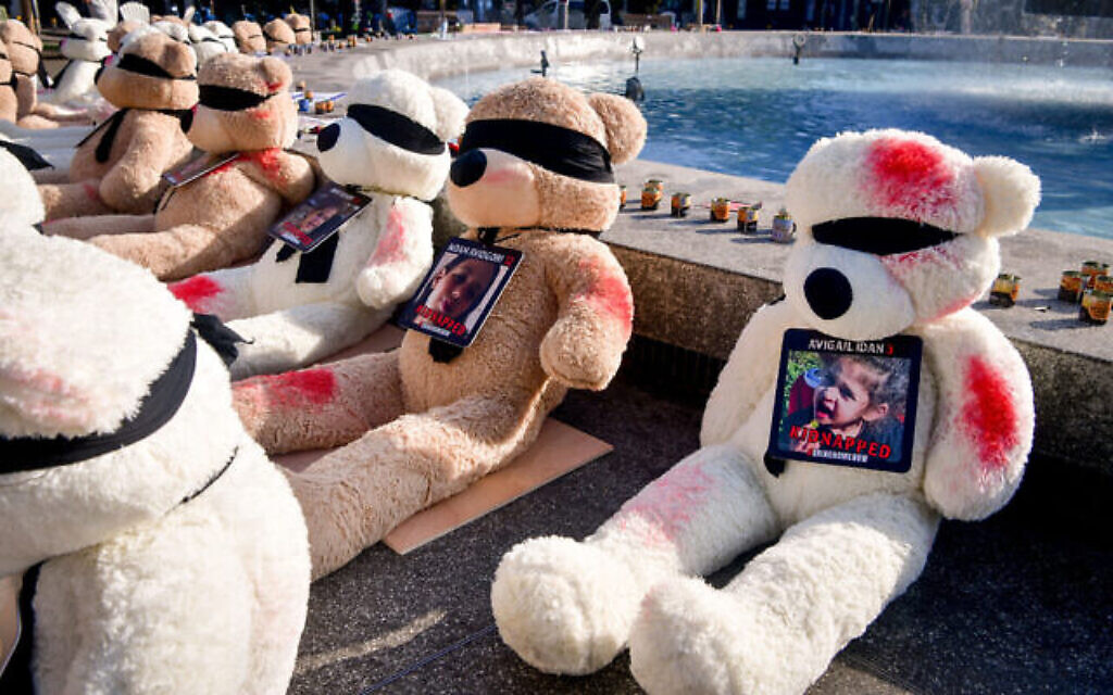 De grands ours en peluche recouverts de peinture rouge et portant des photos des enfants retenus en otage par les terroristes du Hamas à Gaza, sont exposés sur le Kikar Dizengoff, à Tel Aviv, le 25 octobre 2023. (Crédit : Avshalom Sassoni/Flash90) De grands ours en peluche recouverts de peinture rouge et portant des photos des enfants retenus en otage par les terroristes du Hamas à Gaza, sont exposés sur le Kikar Dizengoff, à Tel Aviv, le 25 octobre 2023. (Crédit : Avshalom Sassoni/Flash90)