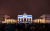 La porte de Brandebourg à Berlin s'illuminant avec le drapeau israélien en signe de solidarité après une attaque du Hamas sur plusieurs fronts, le 7 octobre 2023. (Crédit : Chancelier Olaf Scholz via X)