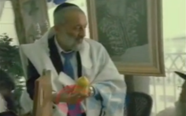 Aryeh Deri debout dans sa souccah, tenant un cédrat qu'il prétend avoir coûté 5 000 dollars, le 1er octobre 2023. (Crédit : Capture d'écran Twitter ; utilisée conformément à l'article 27a de la loi sur le droit d'auteur) Aryeh Deri debout dans sa souccah, tenant un cédrat qu'il prétend avoir coûté 5 000 dollars, le 1er octobre 2023. (Crédit : Capture d'écran Twitter ; utilisée conformément à l'article 27a de la loi sur le droit d'auteur)