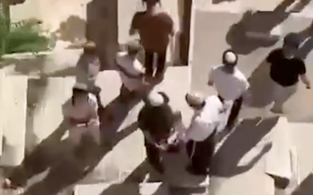 Des Juifs religieux debout sur des tombes au cimetière de Bab al-Rahma, à Jérusalem. (Crédit : Capture d'écran X) Des Juifs religieux debout sur des tombes au cimetière de Bab al-Rahma, à Jérusalem. (Crédit : Capture d'écran X)