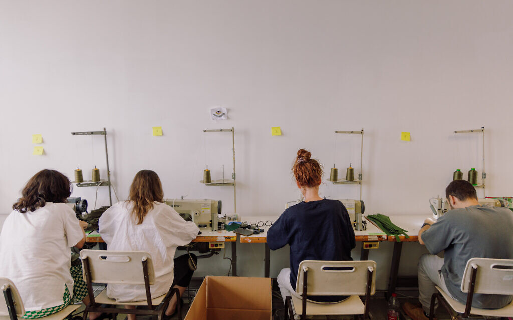 Des centaines de bénévoles se relayant chaque jour à l'école de design Shenkar pour aider l'armée israélienne à équiper les soldats lors de la guerre Israël-Hamas 2023, à Tel Aviv. (Crédit : Yahav Trudler)