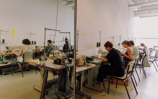 Des centaines de bénévoles se relayant chaque jour à l'école de design Shenkar pour aider l'armée israélienne à équiper les soldats lors de la guerre Israël-Hamas 2023, à Tel Aviv. (Crédit : Yahav Trudler)