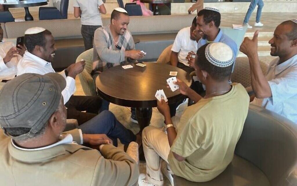 De récents olim originaires d'Éthiopie jouent aux cartes au Nir Etzion Resort, dans le nord d'Israël, le 15 octobre 2023. (Crédit : Sue Surkes/Times of Israël)