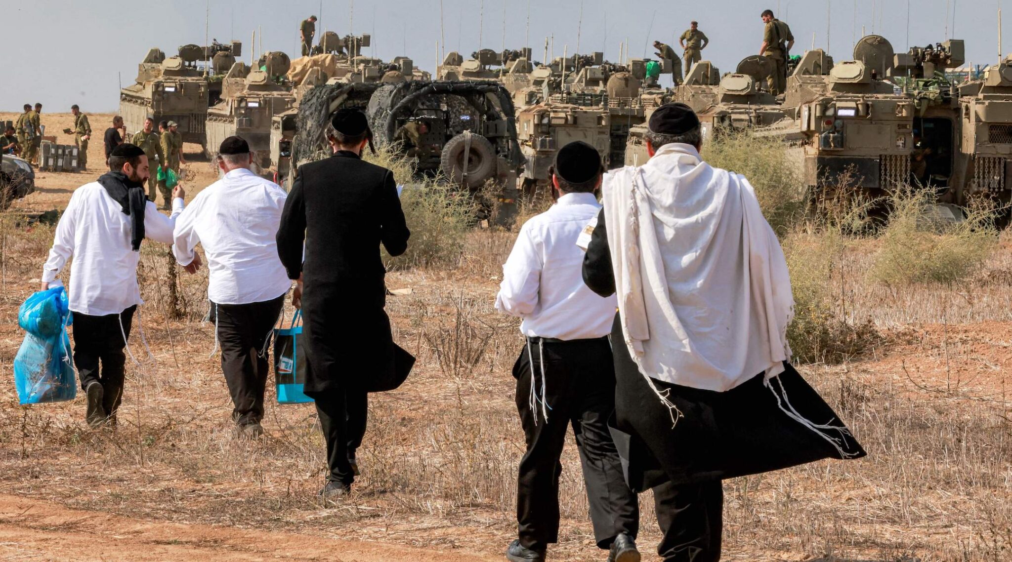 Des Juifs haredim venant afficher leur soutien aux soldats israéliens déployés sur une position située à proximité de la frontière avec Gaza, dans le sud d'Israël, le 11 octobre 2023. (Crédit : Menahem Kahana/AFP)