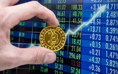 Une pièce de monnaie bitcoin dorée devant un graphique boursier. (Crédit : Getty Images) 