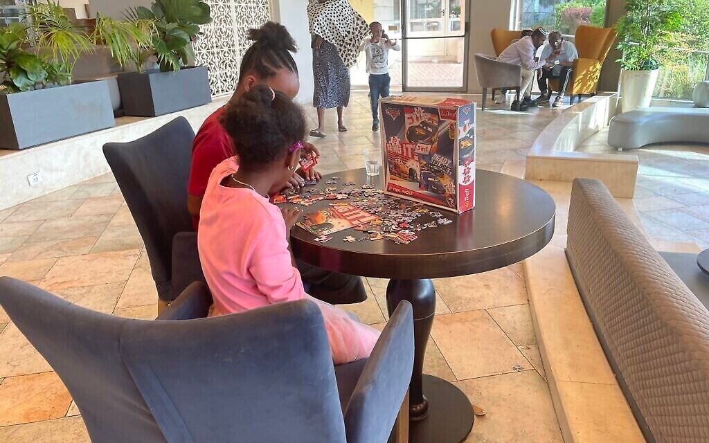 Deux jeunes olim originaires d'Éthiopie s'affairent sur un puzzle au Nir Etzion Resort, dans le nord d'Israël, le 15 octobre 2023. (Crédit : Sue Surkes/Times of Israël)