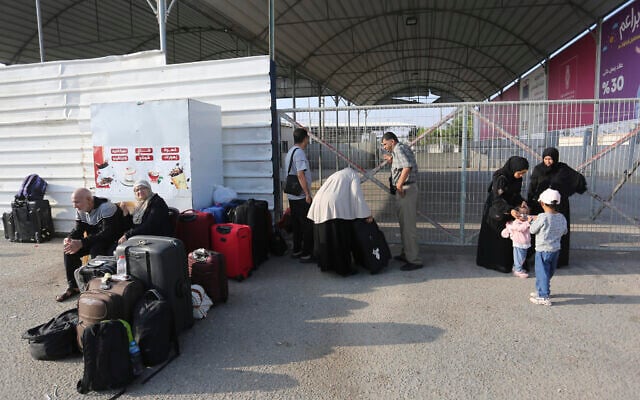 Des Palestiniens attendent au poste frontière entre la bande de Gaza et l'Égypte, à Rafah, le 1er novembre 2023. (Crédit : Hatem Ali/AP) Des Palestiniens attendent au poste frontière entre la bande de Gaza et l'Égypte, à Rafah, le 1er novembre 2023. (Crédit : Hatem Ali/AP)