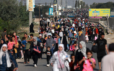 Des Palestiniens fuyant la ville de Gaza vers le sud marchent sur une route le 8 novembre 2023. (Crédit : MOHAMMED ABED / AFP)