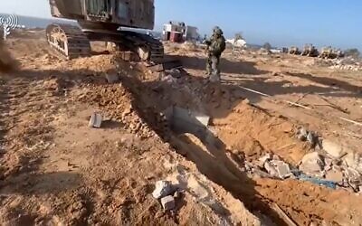 Des soldats de Tsahal à Gaza exposant l'entrée d'un tunnel du Hamas, novembre 2023. (Crédit : Capture d'écran/Tsahal)