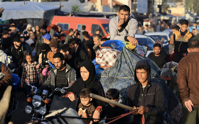 Les Palestiniens qui s'étaient réfugiés dans des abris temporaires retournent chez eux dans l'est de Khan Younis, dans le sud de la bande de Gaza, pendant les premières heures de la trêve de quatre jours entre Israël et le Hamas, le 24 novembre 2023. (Crédit : Mahmud Hams/ AFP) Les Palestiniens qui s'étaient réfugiés dans des abris temporaires retournent chez eux dans l'est de Khan Younis, dans le sud de la bande de Gaza, pendant les premières heures de la trêve de quatre jours entre Israël et le Hamas, le 24 novembre 2023. (Crédit : Mahmud Hams/ AFP)
