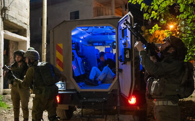 Les troupes israéliennes arrêtent un Palestinien recherché dans la ville de Beit Furik en Cisjordanie, le 28 novembre 2023. (Crédit : Emanuel Fabian/Times of Israel)