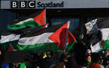 Des drapeaux palestiniens agités devant la BBC Scotland alors que des personnes participent à une manifestation anti-israélienne, à Glasgow, le 14 octobre 2023, en soutien à « leur droit à la résistance ». Sur l'une des banderoles, on peut lire : « Du fleuve à la mer, la Palestine sera libre » – un appel à la destruction d'Israël. (Crédit : Andy Buchanan/AFP)