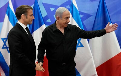 Le Premier ministre Benjamin Netanyahu, à droite, saluant le président français Emmanuel Macron avant une réunion à Jérusalem, le 24 octobre 2023. (Crédit : Christophe Ena/POOL/AFP)