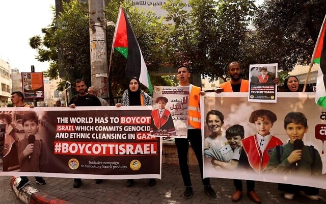 Des Palestiniens brandissent des affiches demandant le boycott des produits israéliens lors d'un rassemblement dans la ville de Hébron en Cisjordanie, le 28 octobre 2023. (Crédit : HAZEM BADER / AFP) Des Palestiniens brandissent des affiches demandant le boycott des produits israéliens lors d'un rassemblement dans la ville de Hébron en Cisjordanie, le 28 octobre 2023. (Crédit : HAZEM BADER / AFP)