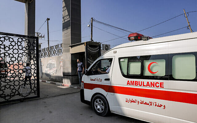 Des ambulances palestiniennes franchissent la porte du poste frontière de Rafah, dans le sud de la bande de Gaza, avant de passer en Égypte, le 1er novembre 2023. (Crédit : Mohammed ABED / AFP)
