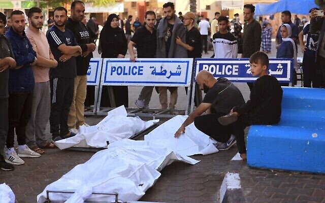 Des Palestiniens prient autour des corps des victimes des bombardements israéliens avant leur inhumation à Deir el-Balah, dans le centre de la bande de Gaza, le 10 novembre 2023. (Photo de Mahmud Hams/AFP)