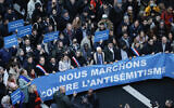 L'écrivain, artiste et militant des droits de l'homme français d'origine polonaise Marek Halter (4e à droite) et des représentants politiques défilant sous une banderole intitulée "Nous marchons contre l'antisémitisme", à Paris, le 12 novembre 2023. (Crédit : Geoffroy Van der Hasselt/AFP)