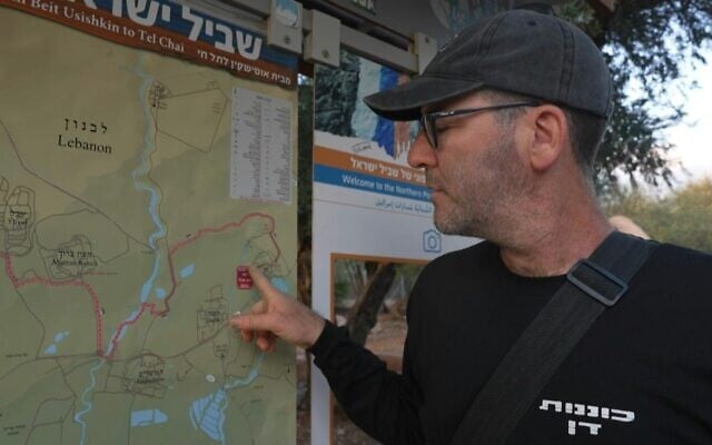Dans son kibboutz quasi-désertique de Kiryat Shmona, Yoav Hermoni, membre de l'équipe d'intervention rapide du kibboutz, porte une arme et consulte une carte, le 15 novembre 2023, dans un contexte de tensions transfrontalières croissantes, alors que les combats se poursuivent avec le Hamas dans le sud de la bande de Gaza. (Crédit : AFP)