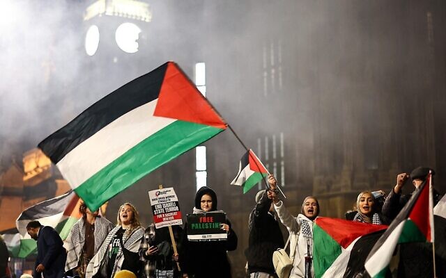 Des manifestants tenant des pancartes et des drapeaux et scandant des slogans lors d'un rassemblement en faveur des Palestiniens et contre Israël, devant les Chambres du Parlement, dans le centre de Londres, le 15 novembre 2023. (Crédit : Henry Nicholls/AFP)