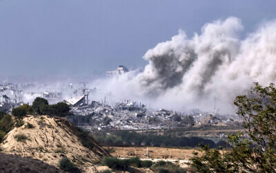 Cette photo prise dans le sud d'Israël montre de la fumée s'élevant au-dessus des bâtiments lors d'une frappe israélienne sur la bande de Gaza, le 19 novembre 2023. (Crédit : KENZO TRIBOUILLARD / AFP)