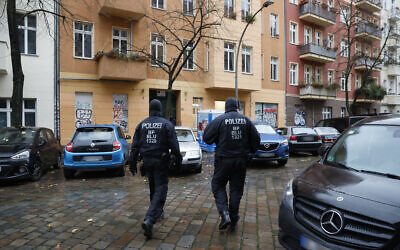 Des policiers se tiennent devant une maison dans le quartier de Friedrichshain à Berlin, lors d'une perquisition contre le Hamas et Samidoun, tous deux interdits dans le pays, le 23 novembre 2023. (rédit : Odd ANDERSEN/AFP)