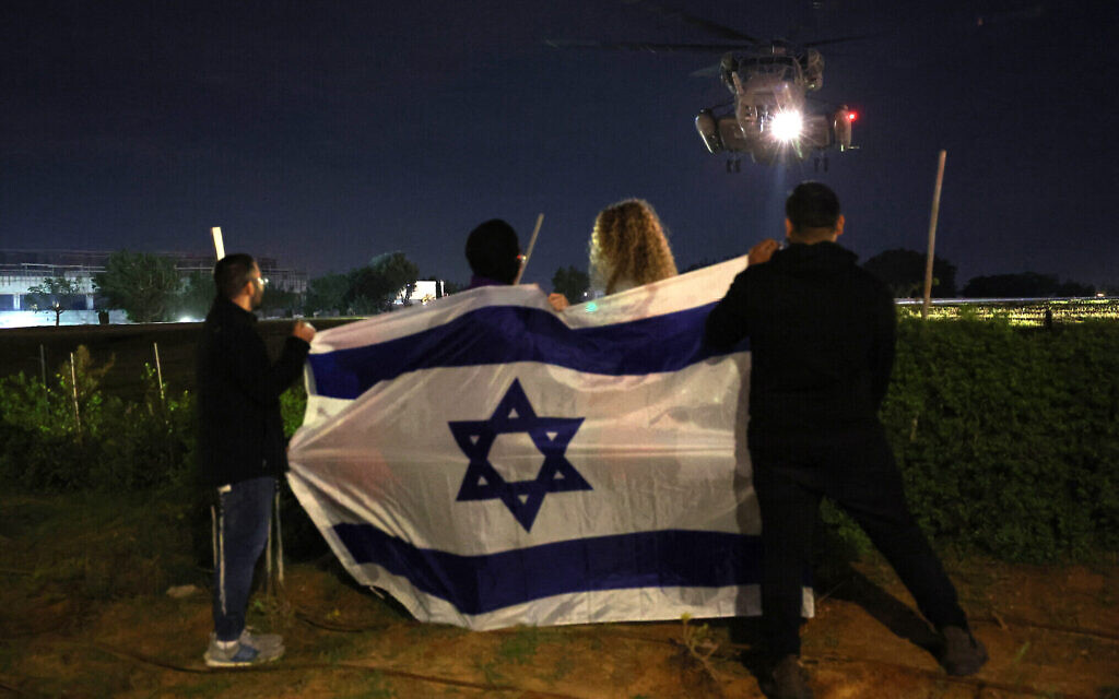 Des Israéliens accueillent un hélicoptère transportant des otages libérés par le Hamas vers l'hôpital Sheba, le 28 novembre 2023. (Crédit : JACK GUEZ / AFP)