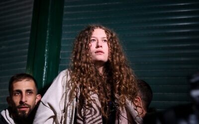 L'activiste palestinienne Ahed Tamimi saluée lors d'une cérémonie de bienvenue suite à la libération de 30 prisonniers palestiniens des prisons israéliennes dans le cadre d'un accord pour les otages israéliens retenus à Gaza, à Ramallah, le 29 novembre 2023. (Crédit : Jaafar Ashtiyeh/AFP) L'activiste palestinienne Ahed Tamimi saluée lors d'une cérémonie de bienvenue suite à la libération de 30 prisonniers palestiniens des prisons israéliennes dans le cadre d'un accord pour les otages israéliens retenus à Gaza, à Ramallah, le 29 novembre 2023. (Crédit : Jaafar Ashtiyeh/AFP)