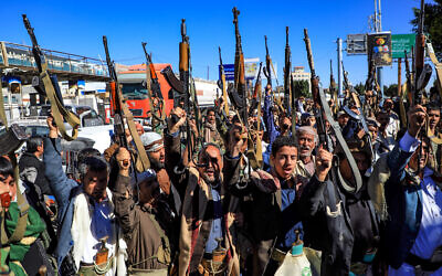 Des partisans yéménites des rebelles Houthis soutenus par l'Iran brandissant leurs armes lors d'un rassemblement dans la capitale Sanaa, le 27 janvier 2022. (Crédit : Mohammed Huwais/AFP)
