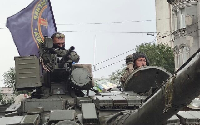 Des militaires assis dans un char portant le drapeau de la société militaire Wagner Group, alors qu'ils gardent une zone au QG du district militaire sud dans une rue de Rostov-sur-le-Don, en Russie, le 24 juin 2023. (Crédit : AP Photo)