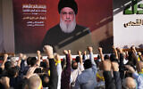 Des partisans du Hezbollah, soutenu par l'Iran, levant le poing et applaudissant alors que le chef Hassan Nasrallah prononce un discours via une liaison vidéo lors d'un rassemblement à Beyrouth, au Liban, le 3 novembre 2023. (Crédit : Hussein Malla/AP)