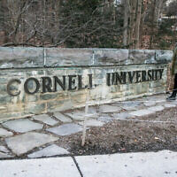 Une femme passant devant un panneau de l'Université Cornell sur le campus de l'école de l'Ivy League, à Ithaca, dans l'État de New York, le 14 janvier 2022. (Crédit : Ted Shaffrey/AP)