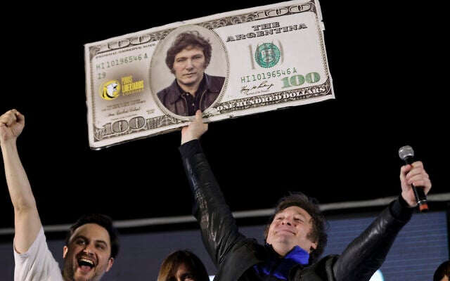 Javier Milei, candidat à la présidence de la coalition Liberty Advances, tient un billet de 100 dollars américains en carton, à son effigie, lors de son meeting de clôture de campagne à Cordoba, en Argentine, le 16 novembre 2023. (Crédit : AP Photo/Nicolas Aguilera)