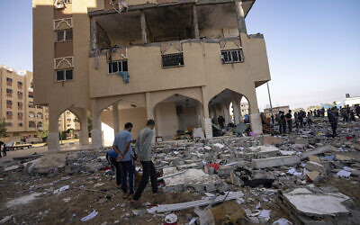 Des Palestiniens observant les destructions après une attaque aérienne israélienne, à Khan Younis, dans le sud de la bande de Gaza, le 18 novembre 2023. (Crédit : Fatima Shbair/AP Photo)
