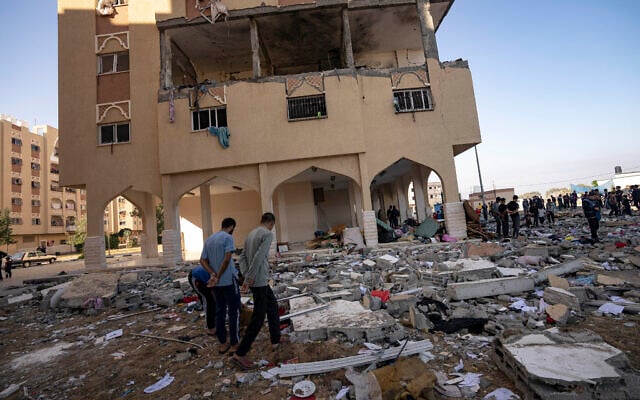 Des Palestiniens observant les destructions après une attaque aérienne israélienne, à Khan Younis, dans le sud de la bande de Gaza, le 18 novembre 2023. (Crédit : Fatima Shbair/AP Photo)