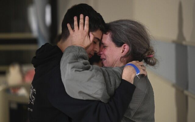 Sharon Hertzman, libérée par le Hamas avec sa fille Noam, 12 ans, à droite, étreint un proche lors de leurs retrouvailles à l'hôpital Sheba de Ramat Gan. (Crédit : Haim Zach/GPO/Handout via AP) Sharon Hertzman, libérée par le Hamas avec sa fille Noam, 12 ans, à droite, étreint un proche lors de leurs retrouvailles à l'hôpital Sheba de Ramat Gan. (Crédit : Haim Zach/GPO/Handout via AP)