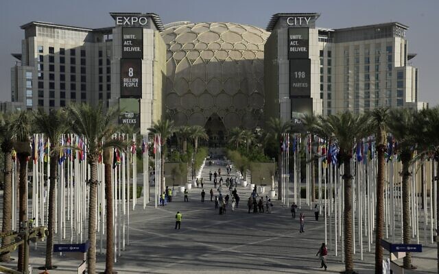 Des personnes traversant le lieu du sommet climatique de l'ONU COP28 avec le dôme al-Wasl en arrière-plan à Expo City, à Dubaï, aux Émirats arabes unis, le 29 novembre 2023. (Crédit : Joshua A. Bickel/AP Photo) Des personnes traversant le lieu du sommet climatique de l'ONU COP28 avec le dôme al-Wasl en arrière-plan à Expo City, à Dubaï, aux Émirats arabes unis, le 29 novembre 2023. (Crédit : Joshua A. Bickel/AP Photo)