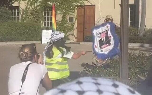 Des étudiants pro-palestiniens de l'Université de Californie frappant une piñata placardée d'une photo du Premier ministre Benjamin Netanyahu, à Los Angeles, le 8 novembre 2023. (Crédit : Capture d'écran/X ; utilisée conformément à l'article 27a de la loi sur le droit d'auteur) Des étudiants pro-palestiniens de l'Université de Californie frappant une piñata placardée d'une photo du Premier ministre Benjamin Netanyahu, à Los Angeles, le 8 novembre 2023. (Crédit : Capture d'écran/X ; utilisée conformément à l'article 27a de la loi sur le droit d'auteur)