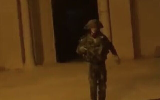 Un soldat israélien s'éloignant après avoir lancé une grenade incapacitante dans une mosquée dans le village de Budrus, en Cisjordanie, le 17 novembre 2023. (Crédit : Capture d'écran X)