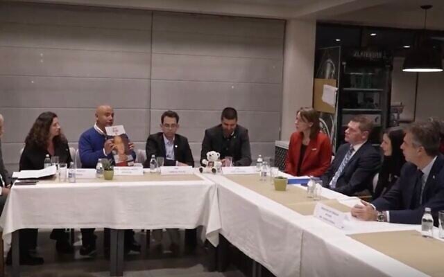 Yaniv Yaakov, tenant une affiche, s'exprimant lors d'un événement avec le ministre des Affaires étrangères Eli Cohen à Skopje, capitale de la Macédoine du Nord, le 30 novembre 2023. (Crédit : Ynet ; utilisée conformément à la clause 27a de la loi sur les droits d'auteur)