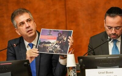 Le ministre des Affaires étrangères d'Israël, Eli Cohen, montrant des photos d'armements terroristes trouvés par Tsahal dans des hôpitaux de Gaza, lors d'une conférence de presse aux bureaux des Nations unies à Genève, le 14 novembre 2023. (Crédit : Pierre-Michel Virot/Délégation israélienne aux bureaux de l'ONU à Genève)