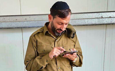 Yanki Deri consulte son téléphone peu de temps après s'être engagé dans l'armée israélienne, près de Tel Aviv, en Israël, le 8 novembre 2023. (Autorisation)