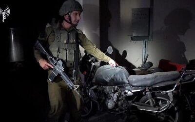 Le porte-parole de l’armée israélienne Daniel Hagari avec une moto dans un centre de commandement du Hamas sous l'hôpital Rantisi, à Gaza CIty, sur une photo publiée le 13 novembre 2023. Hagari a déclaré que Tsahal pense que la moto a été utilisée par les terroristes du Hamas pour enlevé un otage du sud d'Israël et l’emmener jusqu’au centre souterrain le 7 octobre 2023. (Crédit : Armée israélienne)