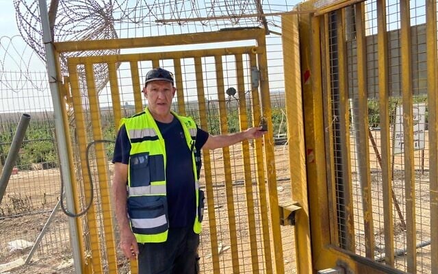 Stevie Marcus à la porte arrière du kibboutz Alumim,  que les terroristes avaient emprunté lors de leur assaut du 7 octobre. Photo prise le 13 novembre 2023. (Crédit :  David Horovitz / Times of Israel)