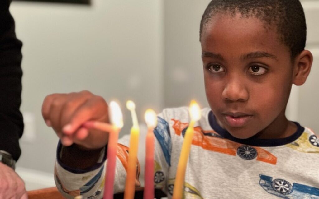 Jack Kulbersh allume une menorah. (Crédit : Project Menorah)